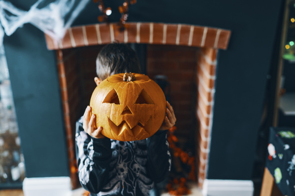 a boy holding a pumpkin head