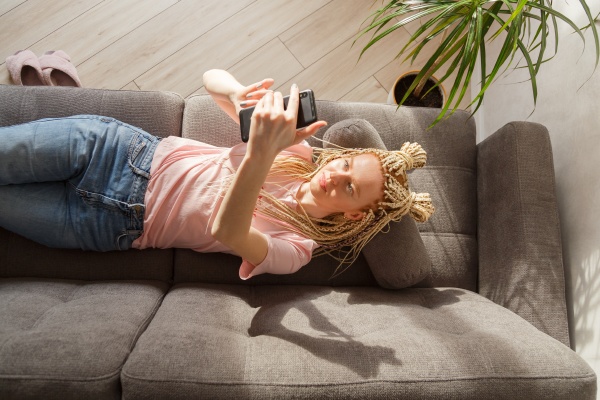 woman use a smartphone while lying