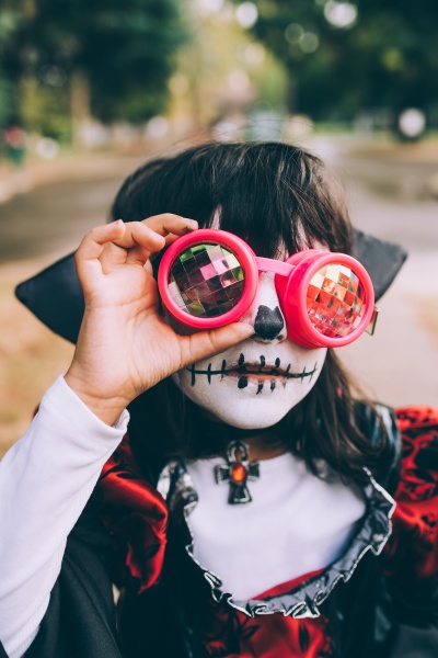 girl wearing halloween costume with face