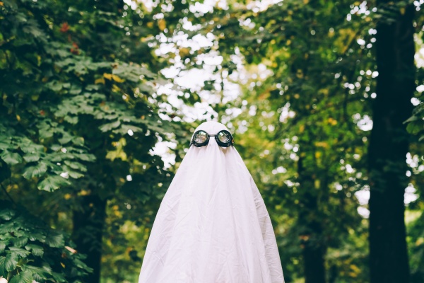 child in forest wearing ghost halloween