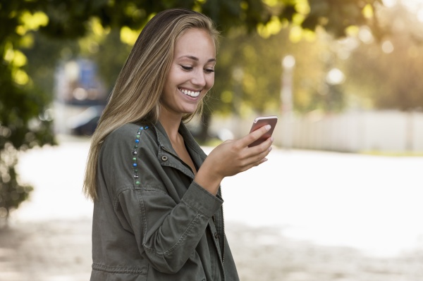 smiling young woman using smart phone