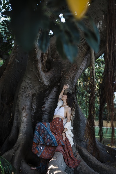 woman touching tree while sitting under