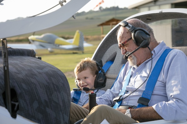 grandson and grandfather sitting inside airplane