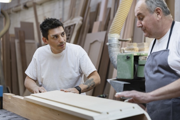 artist discussing while standing by workbench