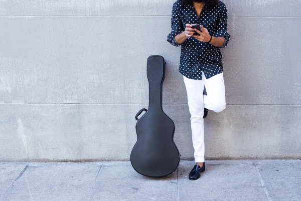 guitarist using mobile phone while standing