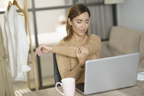 businesswoman stretching hand while working on