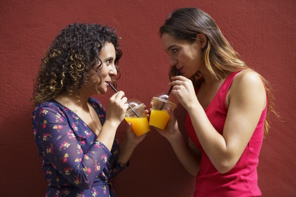 female couple drinking juice while standing