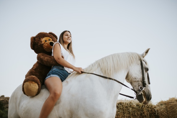 beautiful young woman riding horse with