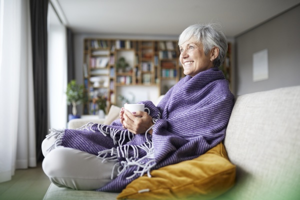 smiling senior woman with blanket holding
