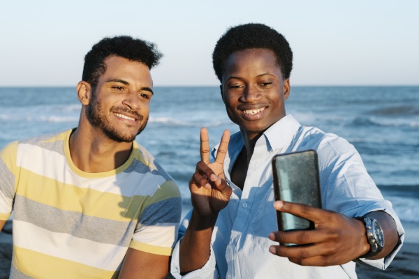 smiling friends taking selfie on smart