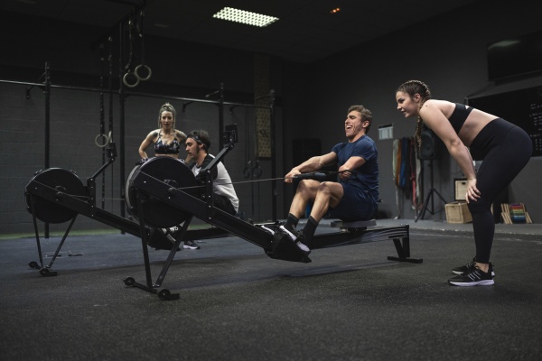 athletes exercising with rowing machine at