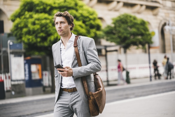 man with bag using mobile phone