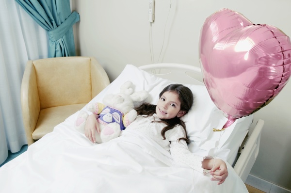 girl holding a balloon on hospital