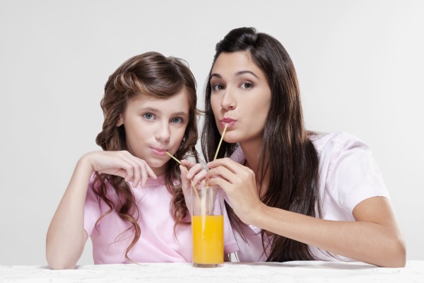 woman with her daughter drinking juice