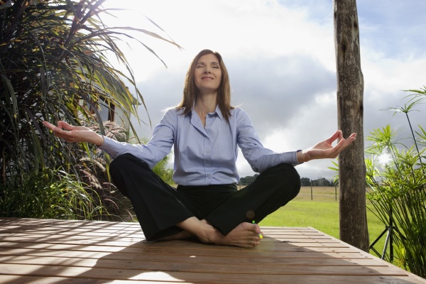 businesswoman meditating in a park
