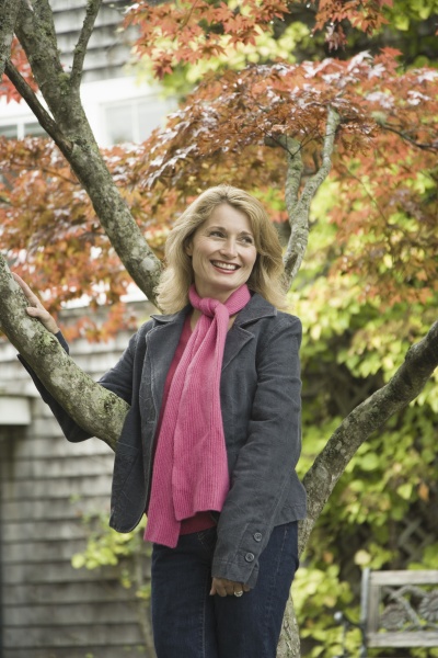 mature woman leaning against a maple