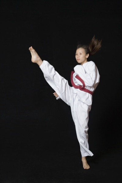 young woman performing round kick