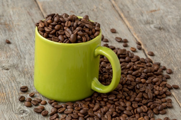 green mug with coffee beans