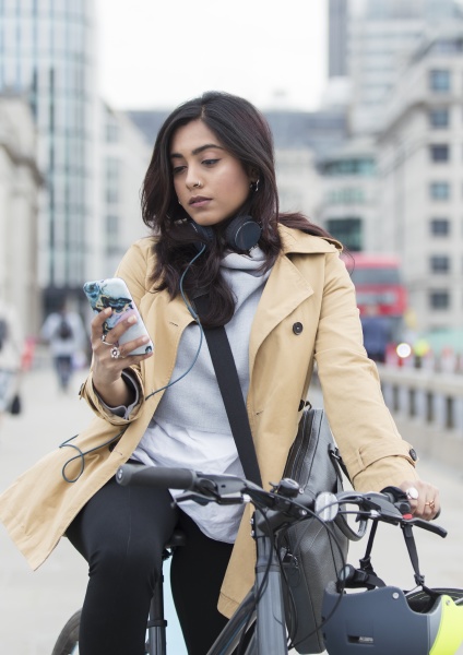 woman on bicycle using smart phone
