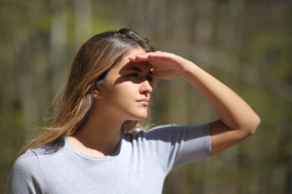 woman protecting from sun looking away
