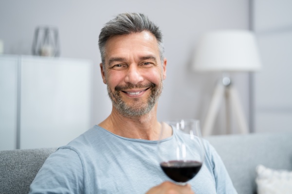 man drinking red wine in video