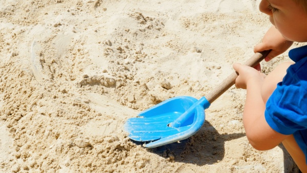 closeup of little boy digging sand