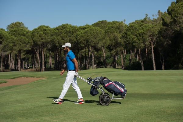 golf player walking with wheel bag