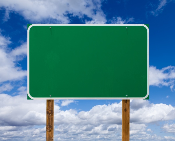 blank green road sign with wooden