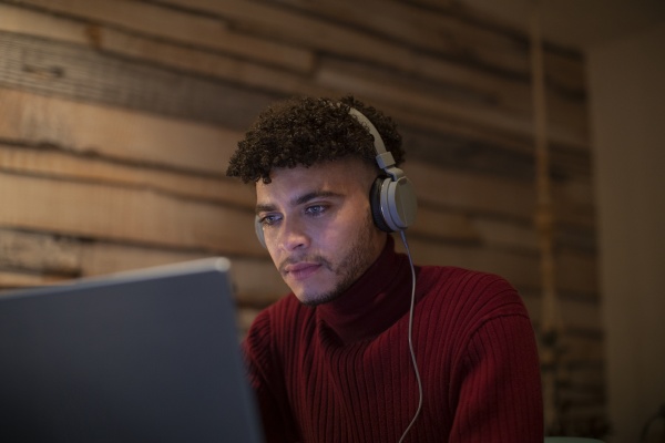 focused young man with headphones using