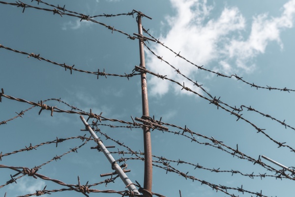 barbed wire fencing against sky background