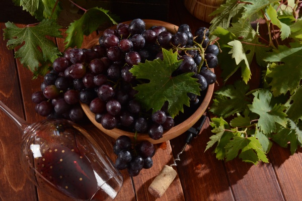 fresh black grapes in wooden bowl