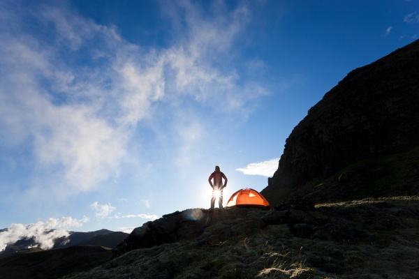 woman standing by tent at sunrise