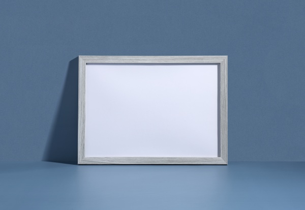 blank picture frame leaning against blue