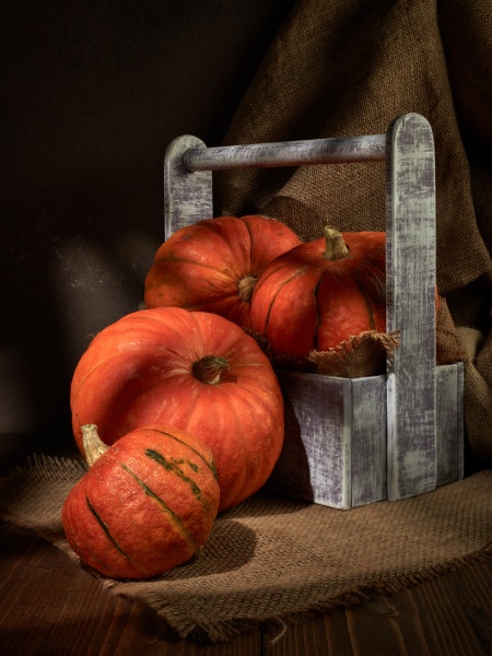 ripe orange pumpkins in wooden box