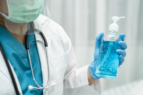 doctor holding blue alcohol sanitizer gel