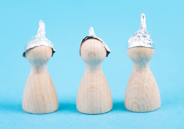 three wooden figures wearing an alu
