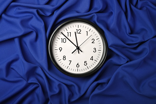 white clock over blue textile folded
