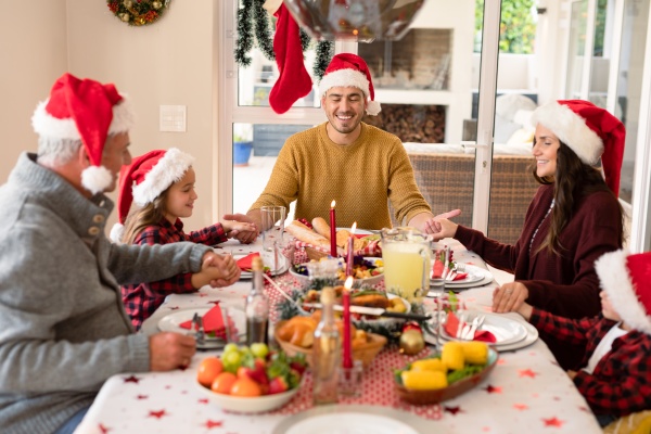 caucasian multi generation family wearing santa