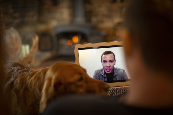 man with dog video chatting with