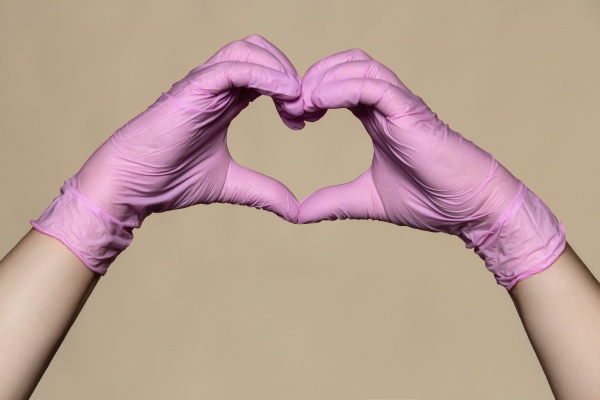 hands in pink protective gloves forming