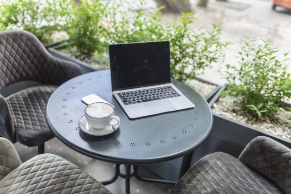 laptop and cappuccino on patio table