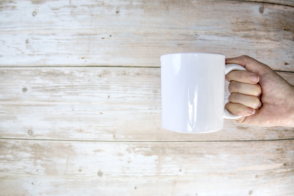 hand holding a ceramic mug blank
