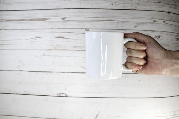 hand holding a ceramic mug blank