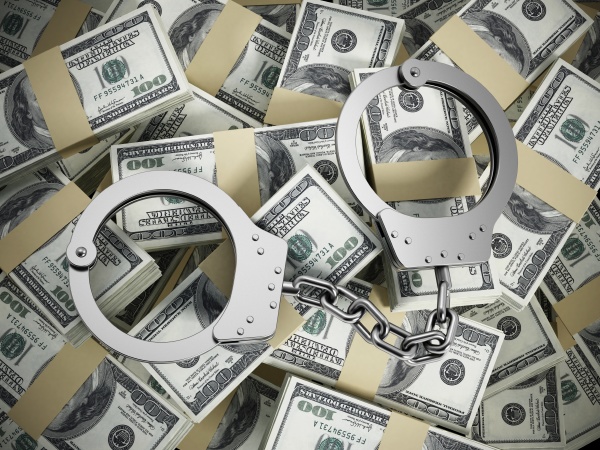 handcuffs on 100 dollar money pile