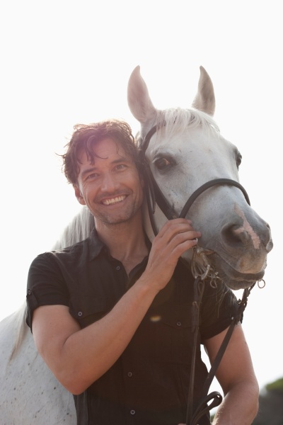man holding horse smiling