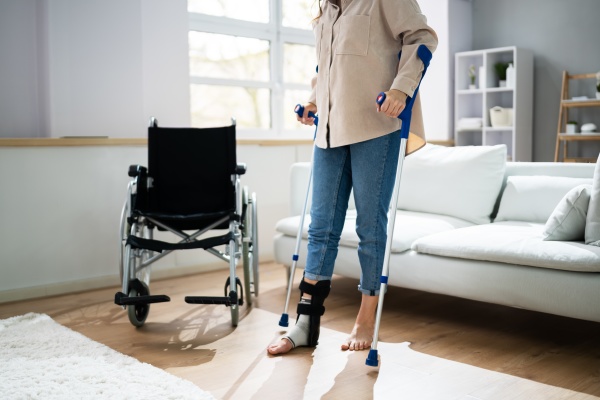 hurt leg using crutches near wheelchair