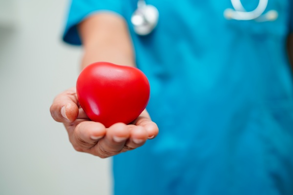 asian woman doctor holding red heart