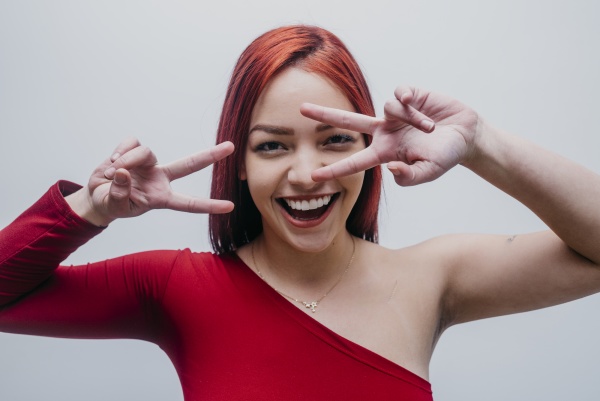 smiling redhead woman making peace sign