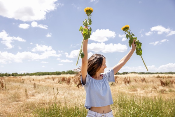 woman holding sunflowers while standing at