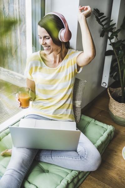 woman listening music holding juice while